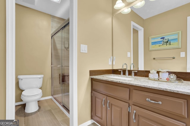 full bathroom with a shower stall, toilet, vanity, and baseboards