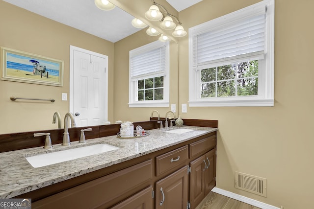 bathroom with double vanity and baseboards
