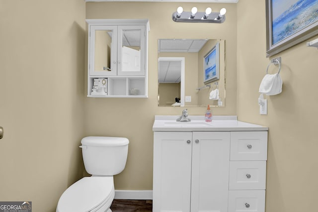 bathroom featuring toilet, vanity, and baseboards