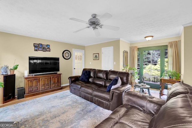 living area with a ceiling fan, ornamental molding, wood finished floors, and baseboards