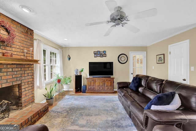 living room featuring ornamental molding, wood finished floors, ceiling fan, baseboards, and a fireplace