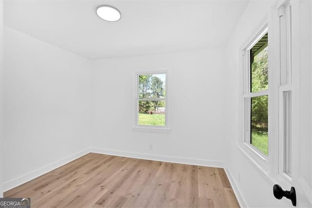 empty room with light wood-style flooring, a healthy amount of sunlight, and baseboards