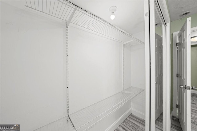 spacious closet with wood finished floors and visible vents