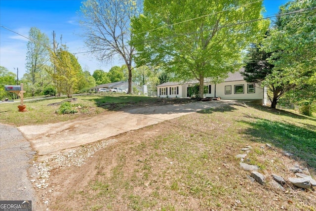 view of front of home featuring driveway, a front lawn, and stucco siding
