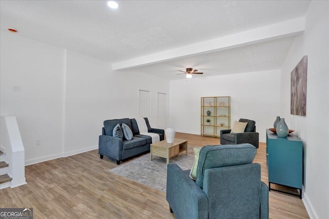living room featuring ceiling fan, beamed ceiling, light wood-style flooring, baseboards, and recessed lighting