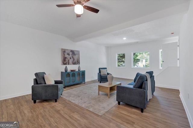 living area featuring baseboards, recessed lighting, beamed ceiling, a ceiling fan, and wood finished floors