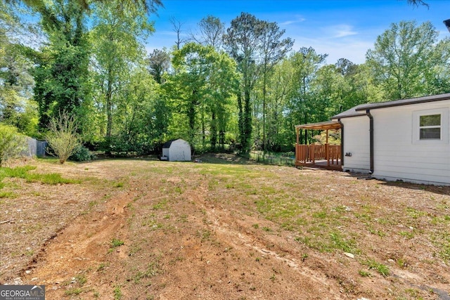 view of yard featuring fence, an outbuilding, and a storage shed