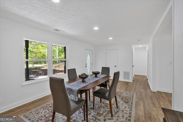 dining room featuring wood finished floors, visible vents, and recessed lighting