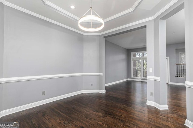 interior space featuring baseboards, a chandelier, dark wood finished floors, crown molding, and a raised ceiling