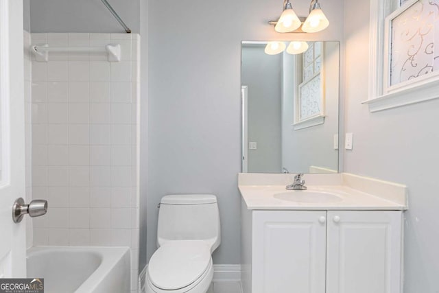 bathroom featuring toilet, vanity, and shower / bathtub combination