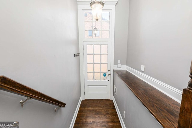 doorway to outside with baseboards and dark wood finished floors