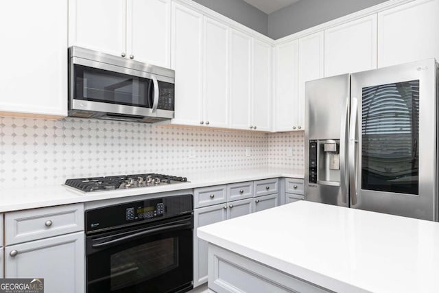 kitchen featuring tasteful backsplash, light countertops, appliances with stainless steel finishes, and white cabinetry
