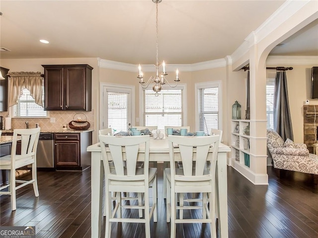 dining room with dark wood-type flooring, arched walkways, crown molding, and a chandelier
