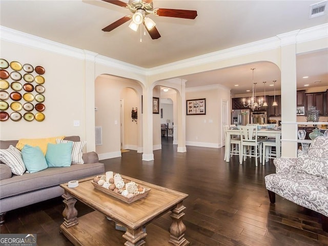 living room featuring visible vents, arched walkways, ceiling fan with notable chandelier, and ornamental molding