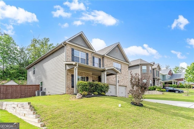 view of front of home with brick siding, a garage, fence, and a front yard