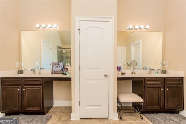 bathroom featuring two vanities, tile patterned floors, a shower stall, and a sink