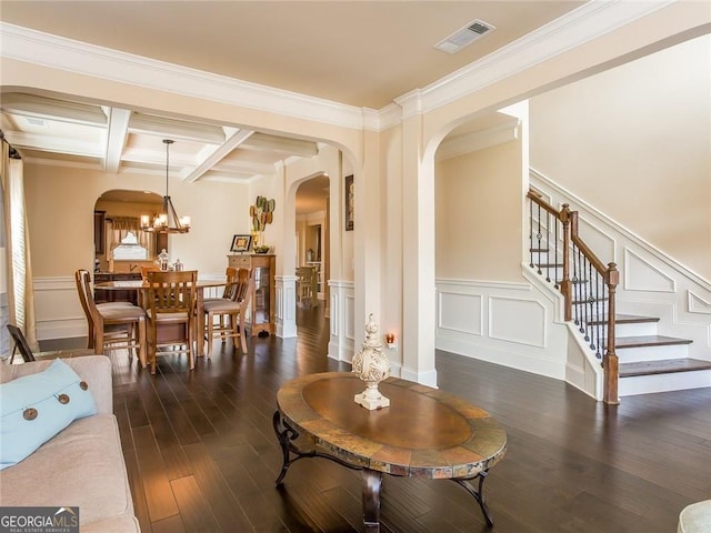 living area featuring a decorative wall, arched walkways, visible vents, dark wood-style floors, and coffered ceiling