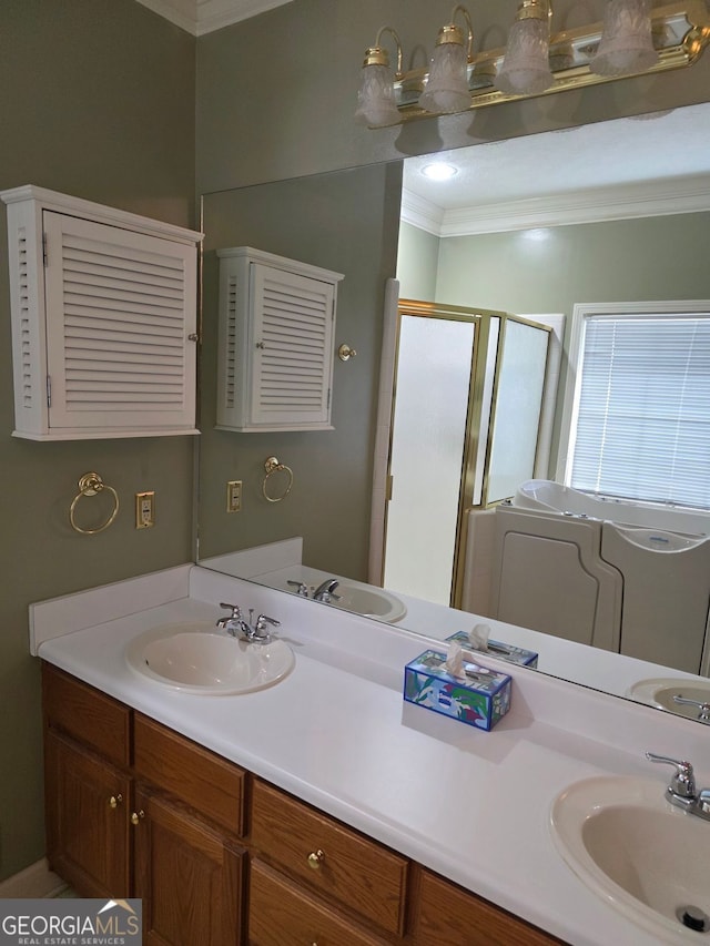 full bathroom with double vanity, a stall shower, a sink, and ornamental molding