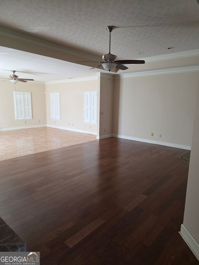 empty room featuring baseboards, a ceiling fan, ornamental molding, and dark wood finished floors