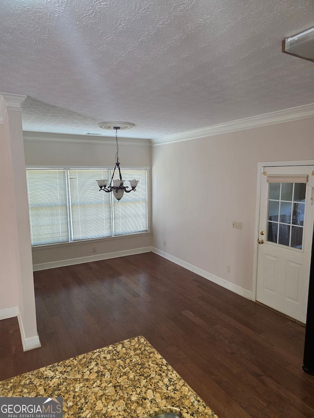 unfurnished dining area featuring dark wood-style flooring, baseboards, an inviting chandelier, and a textured ceiling