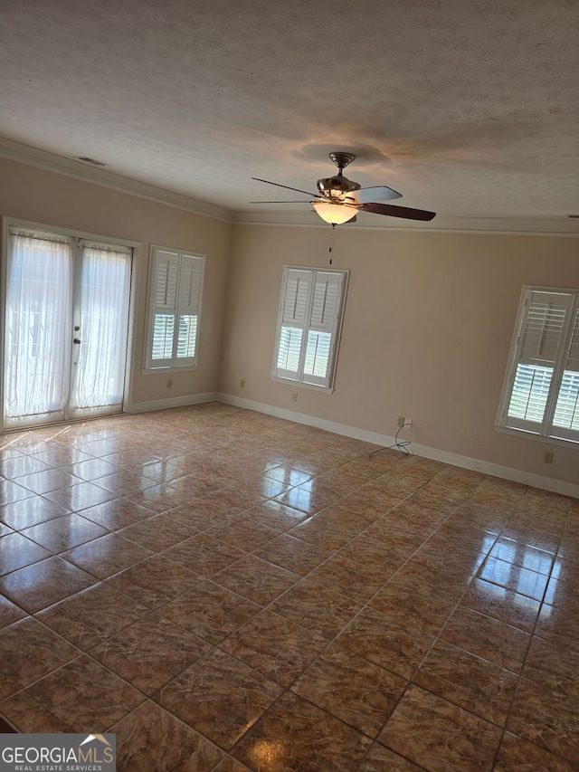 spare room with dark tile patterned flooring, a wealth of natural light, and baseboards