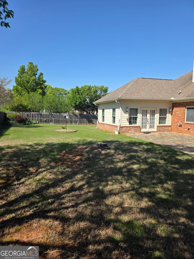 view of yard with a patio area, french doors, and fence private yard