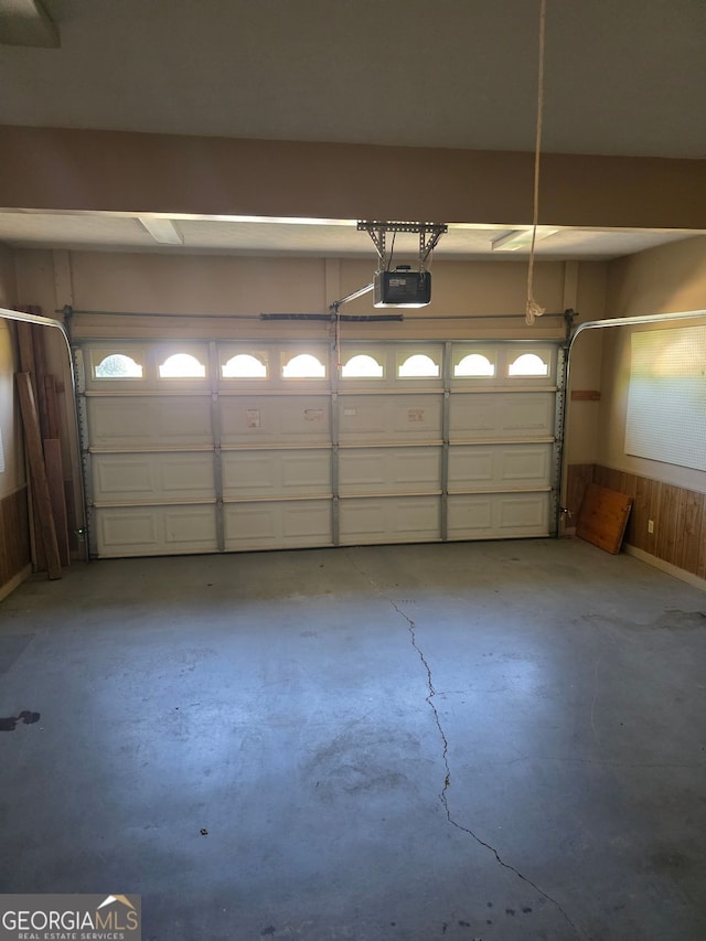 garage featuring wood walls and a garage door opener