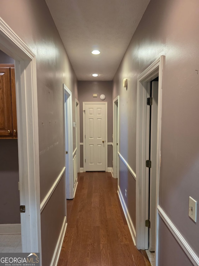 hallway with baseboards, dark wood finished floors, and recessed lighting
