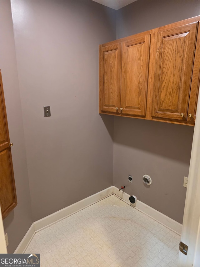 laundry room featuring hookup for a gas dryer, baseboards, and cabinet space