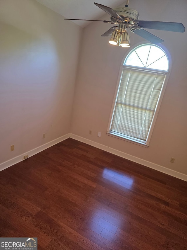 spare room featuring dark wood finished floors, baseboards, and a ceiling fan