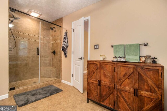 469 Kimberly Ct, Mcdonough, GA 30252 - full bathroom featuring a shower stall, a textured ceiling, and tile patterned flooring