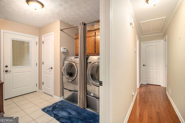 469 Kimberly Ct, Mcdonough, GA 30252 - laundry area featuring cabinet space, attic access, washing machine and clothes dryer, light wood-style flooring, and crown molding