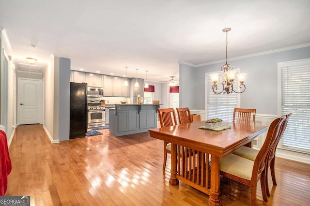 469 Kimberly Ct, Mcdonough, GA 30252 - dining area with light wood-style floors, ornamental molding, a chandelier, and wainscoting