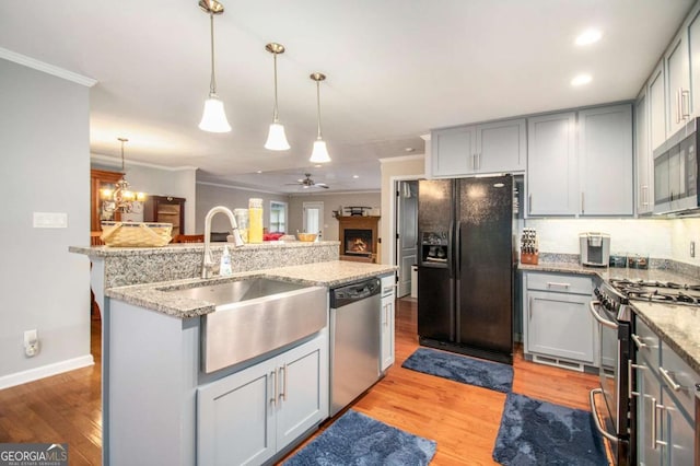 469 Kimberly Ct, Mcdonough, GA 30252 - kitchen with stainless steel appliances, gray cabinets, ornamental molding, light wood-style floors, and a ceiling fan