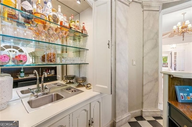bar with a sink, tile patterned floors, bar, and a chandelier