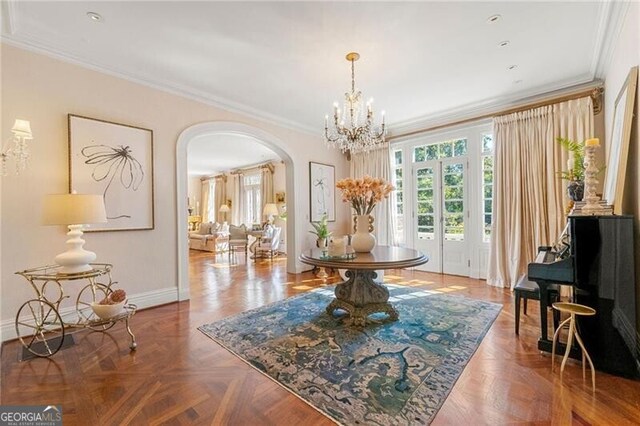 dining area featuring arched walkways, an inviting chandelier, crown molding, and baseboards