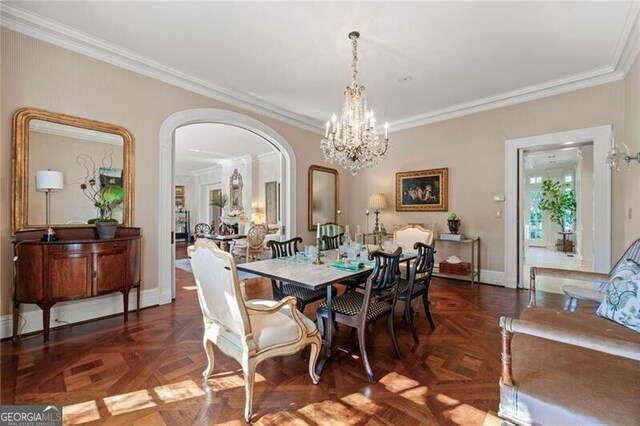 dining room featuring ornamental molding, baseboards, arched walkways, and a notable chandelier