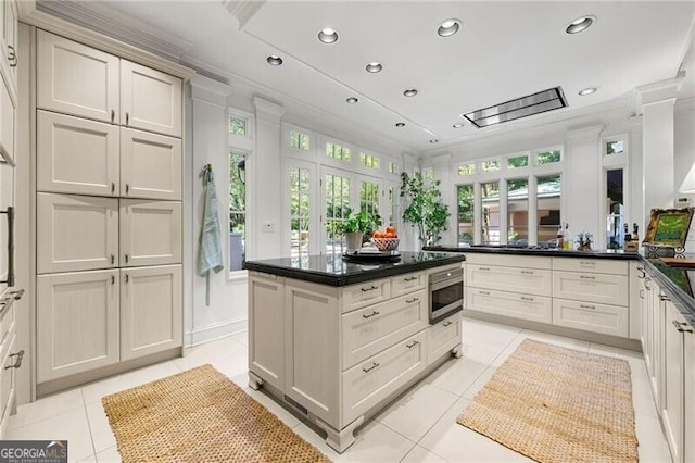 kitchen with light tile patterned flooring, stainless steel microwave, dark countertops, and recessed lighting
