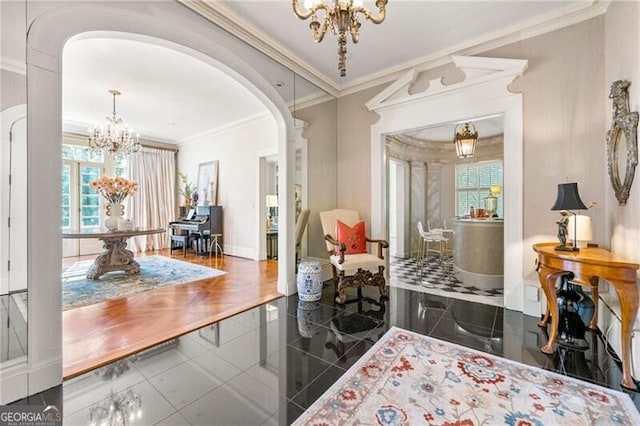 interior space with crown molding, baseboards, arched walkways, and a chandelier