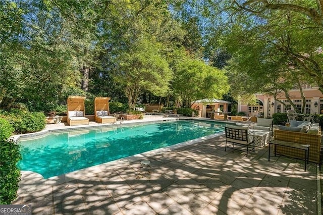 outdoor pool featuring a patio area and an outdoor structure