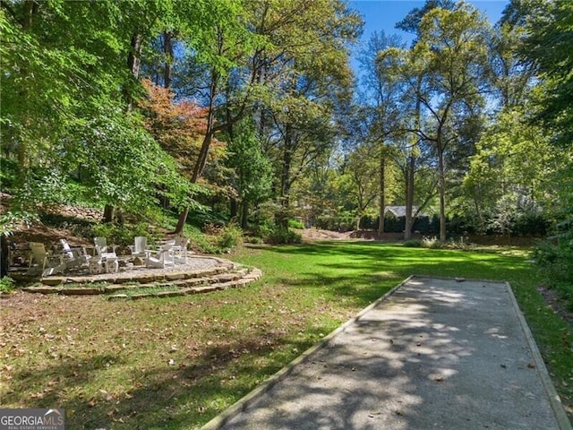 view of home's community with a fire pit and a lawn