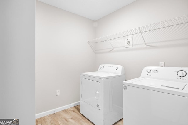 laundry area with laundry area, baseboards, light wood-type flooring, and washer and clothes dryer