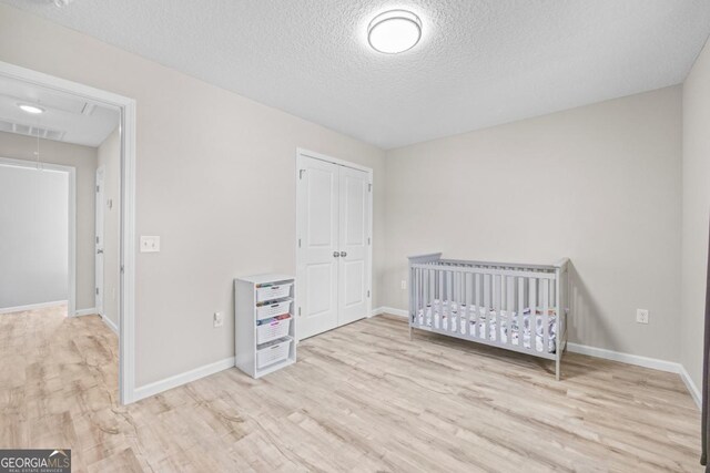 141 Cardinal Ln, Jesup, GA 31545 - unfurnished bedroom with attic access, light wood finished floors, a closet, and a textured ceiling