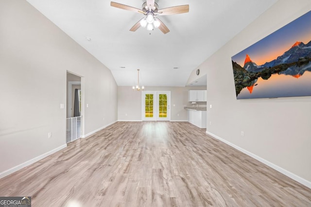 unfurnished living room with baseboards, light wood-type flooring, vaulted ceiling, french doors, and ceiling fan with notable chandelier