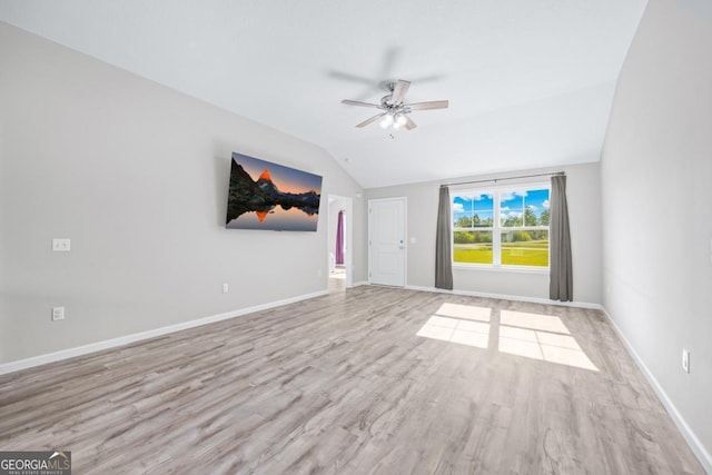 unfurnished room with wood finished floors, baseboards, a ceiling fan, and vaulted ceiling