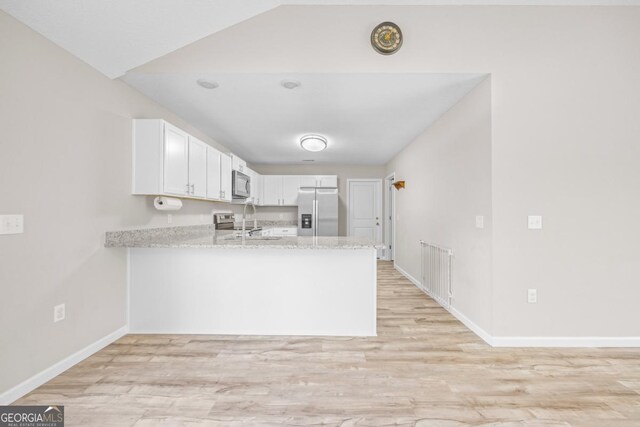 141 Cardinal Ln, Jesup, GA 31545 - kitchen featuring appliances with stainless steel finishes, a peninsula, light wood finished floors, and white cabinetry