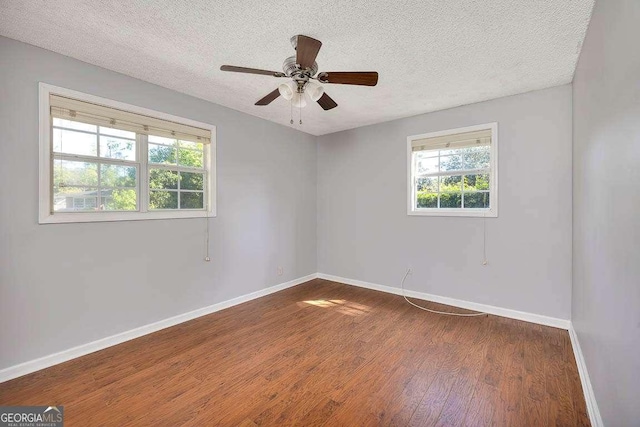 unfurnished room with baseboards, ceiling fan, wood finished floors, and a textured ceiling