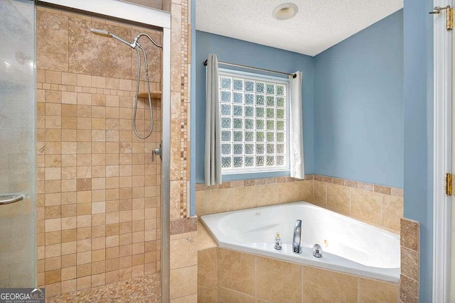 bathroom featuring a shower stall, a textured ceiling, and a garden tub