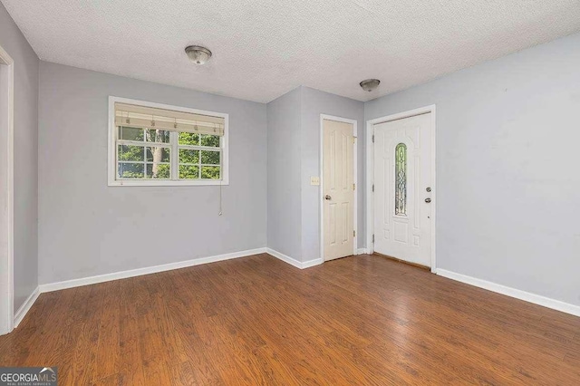 entrance foyer featuring a textured ceiling, wood finished floors, and baseboards