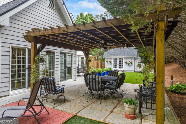 view of patio / terrace with outdoor dining space, a pergola, and an outdoor structure